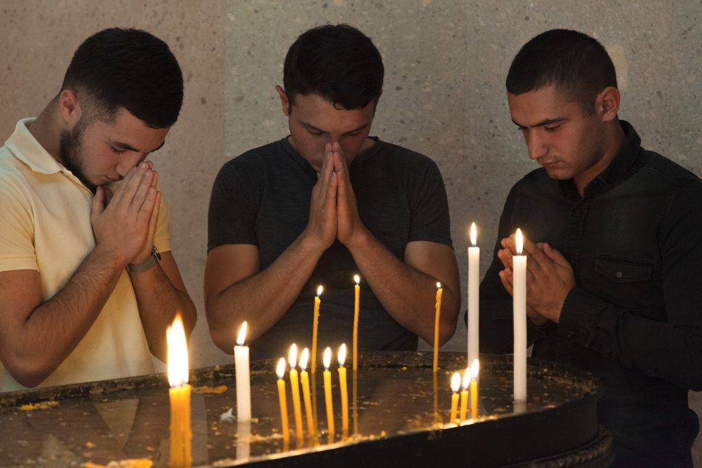 Tre uomini in preghiera nella cattedrale apostolica armena di Stepanakert nel NK (Didier Ruef)