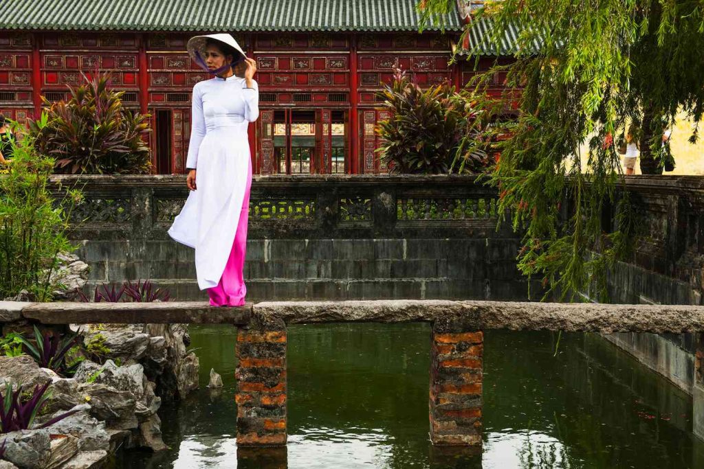 Una donna indossa un abito ao dai e il tradizionale cappello conico, Hue, Vietnam (Keystone)