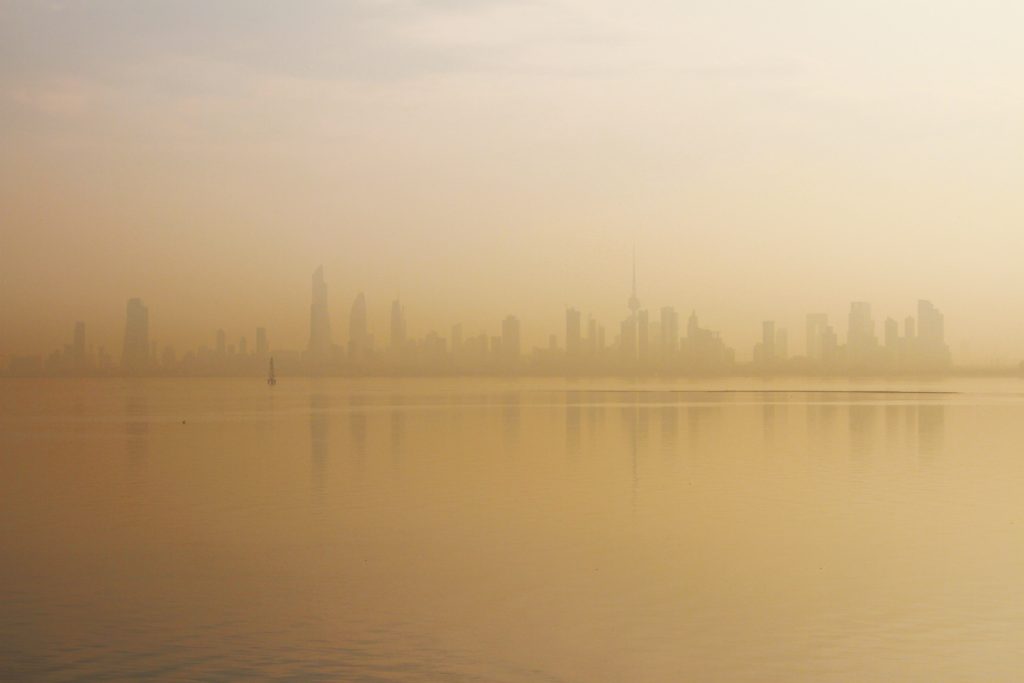 L'alba su Madinat al-Kuwait, tra luci, vento e sabbia