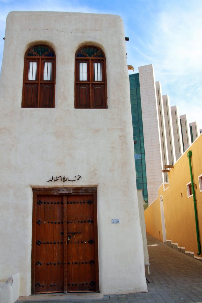 Piccole abitazioni antiche fanno capolino tra gli alti grattacieli della città