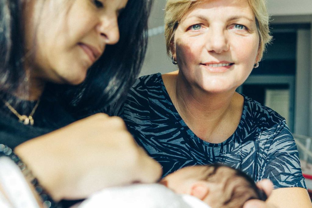 Una mamma mentre allatta il suo bambino, con l’aiuto di Elena Ferrari (Vincenzo Cammarata)