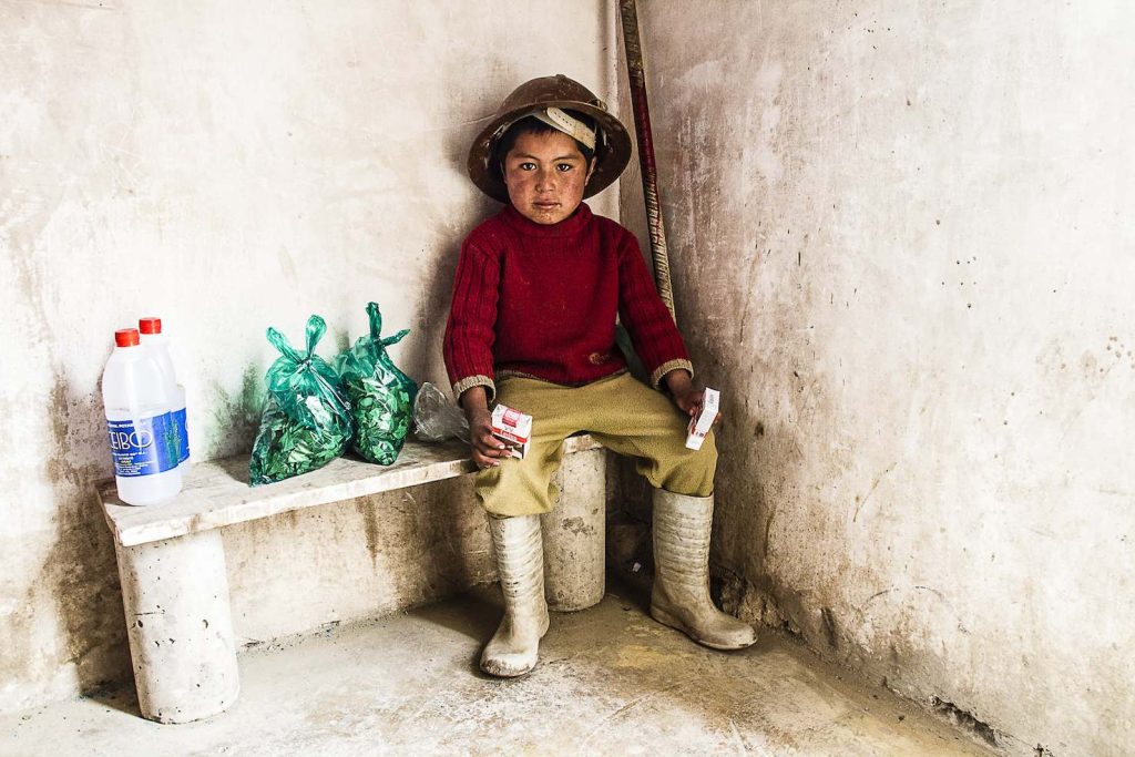 Il piccolo Marcos, orfano, in tenuta da minatore