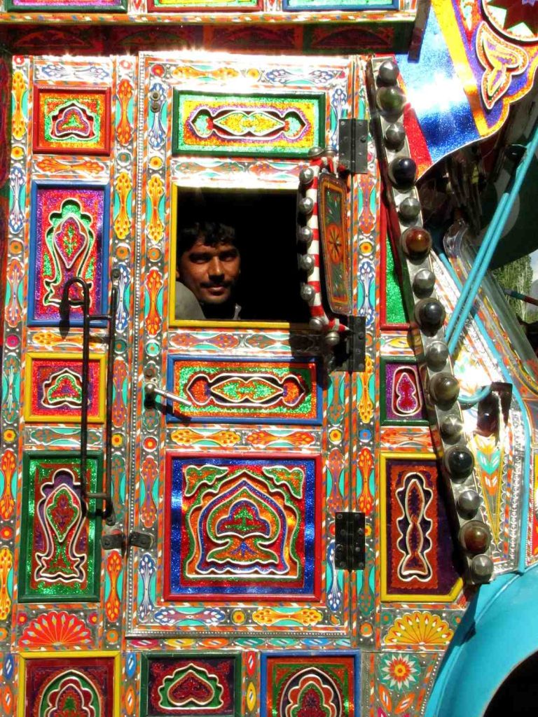 Camionista. I camion pakistani sono sempre decorati e personalizzati, un uso che viene dalle antiche carovane di cammelli