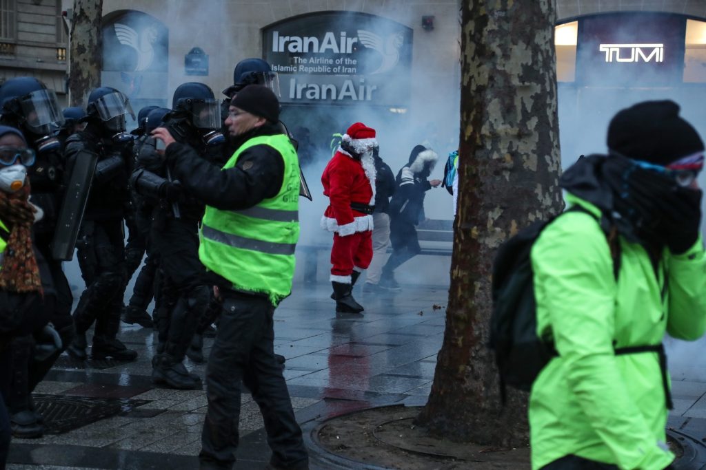 Un gilet giallo vestito da Babbo Natale prende parte a una manifestazione di protesta a Parigi (AFP)