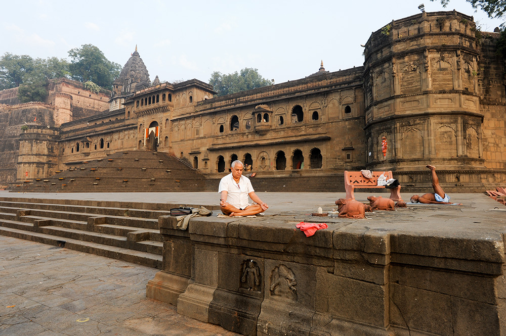 Uomini che praticano yoga e meditazione all’alba nei pressi del tempio di Rama (Stefano Ember)