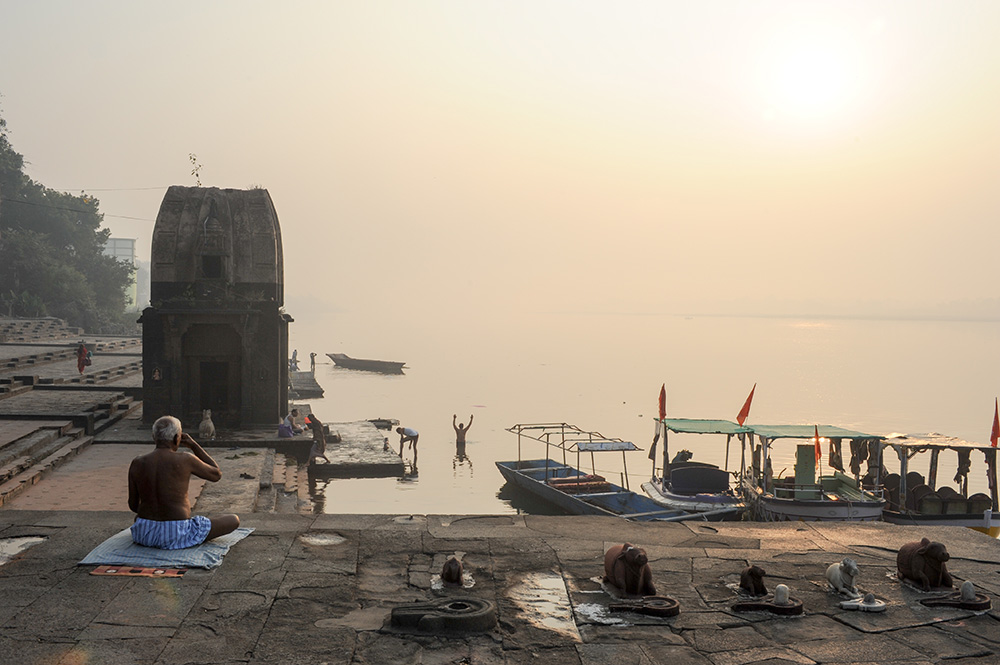 Uomini praticano yoga all’alba con vista sul fiume Narmada (Stefano Ember)