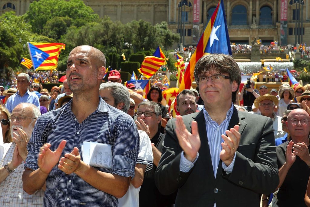 L'icona del calcio Pep Guardiola (a sinistra) con il presidente catalano Carles Puigdemont davanti a migliaia di sostenitori dell'indipendenza (Keystone)