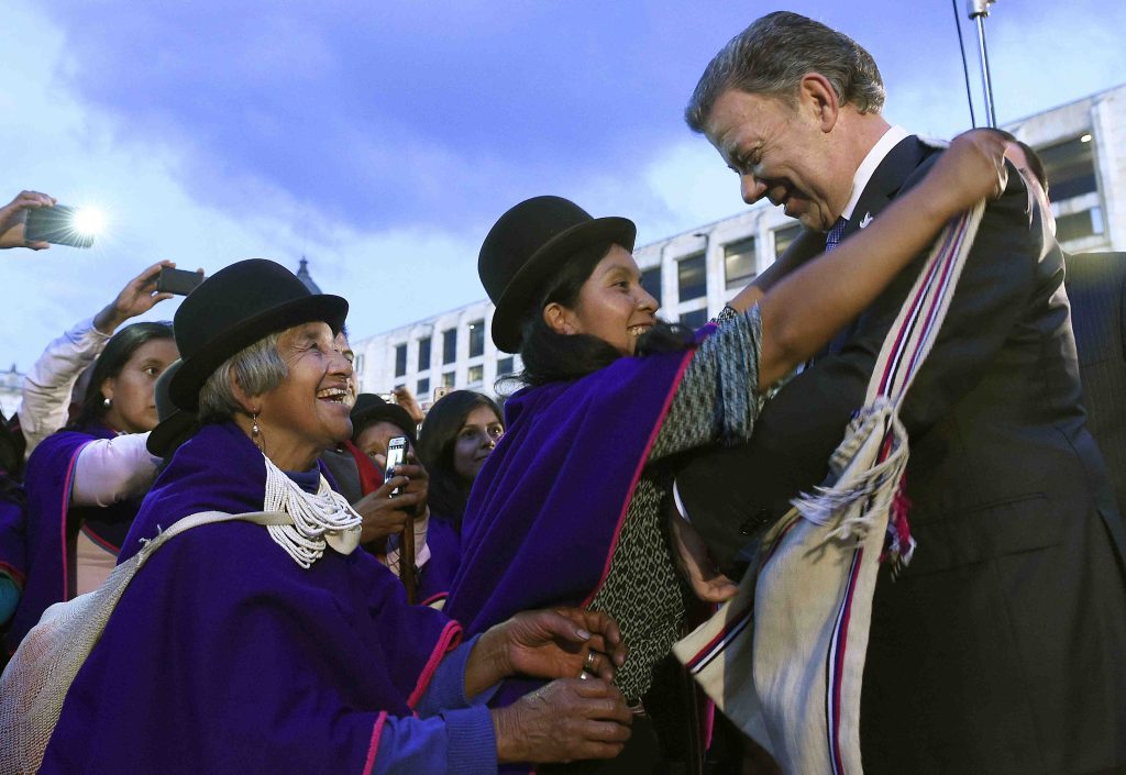 Il presidente colombiano Santos è festeggiato a Bogotà dagli indigeni Misak dopo l’annuncio di Oslo (AFP)