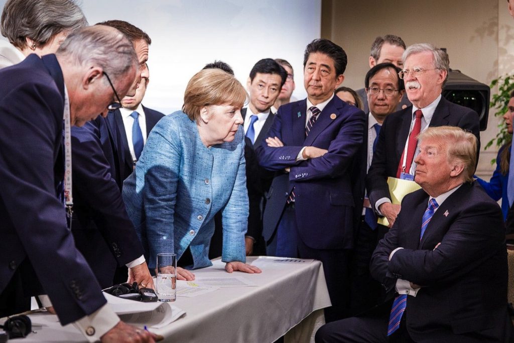 Donald Trump e Angela Merkel  discutono circondati dai leader politici in occasione del G7 svoltosi recentemente in Canada (AFP)