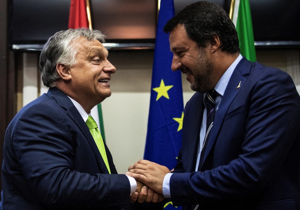 Matteo Salvini stringe la mano a Viktor Orban a Milano in agosto (AFP)