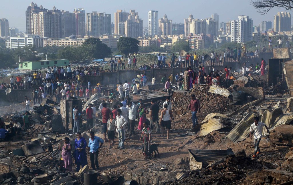 Povertà e ricchezza fianco a fianco in uno slum di Bombay, India (Keystone)
