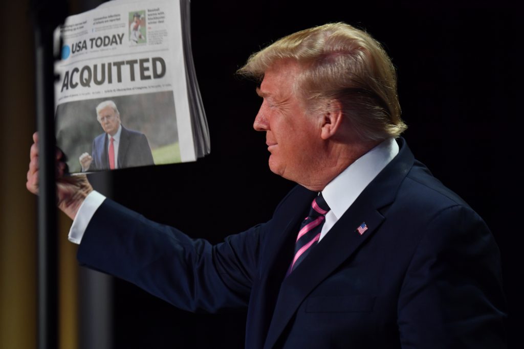 Trump assolto da tutte le accuse gongola mostrando il giornale (AFP)
