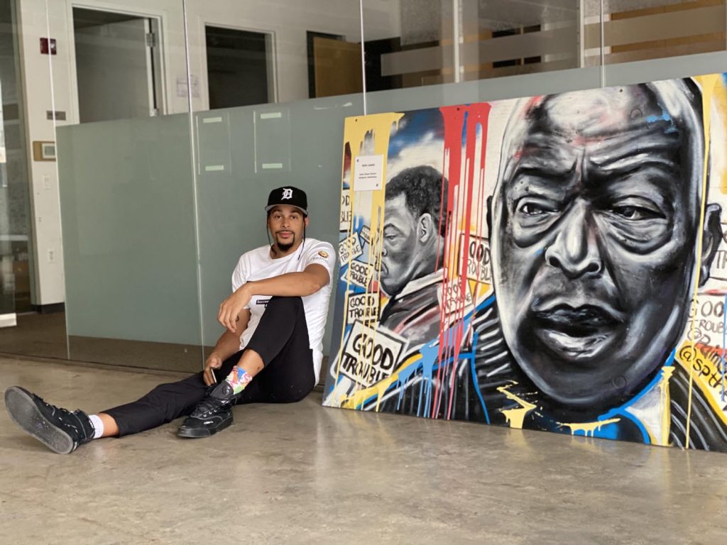 Shawn Perkins, nel suo studio, accanto alla tela dipinta in onore del compianto congressman John Lewis ed esposta al National Building Museum