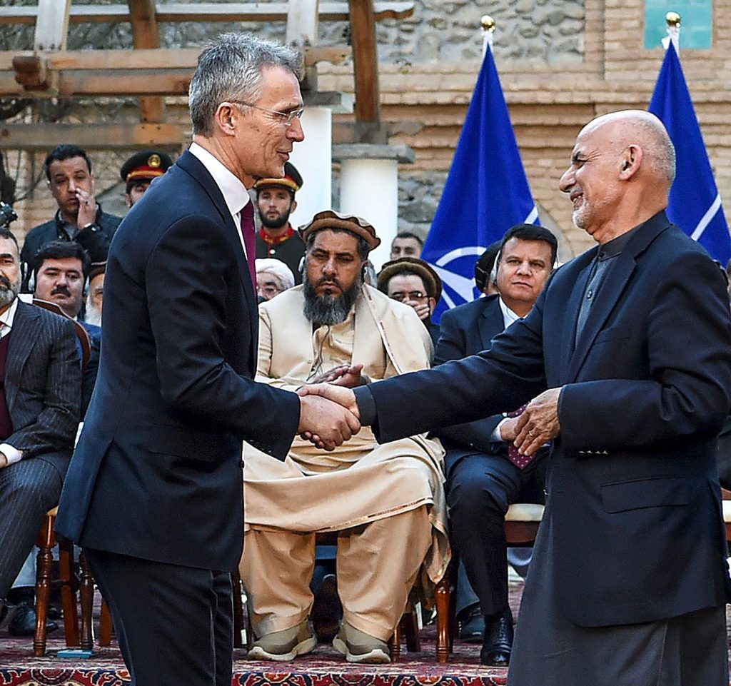 Il presidente afghano Ashraf Ghani (destra) stringe la mano al segretario generale Nato Jens Stoltenberg (AFP)