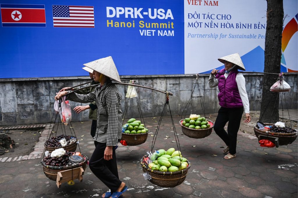Venditrici di frutta camminano nelle strade di Hanoi (AFP)