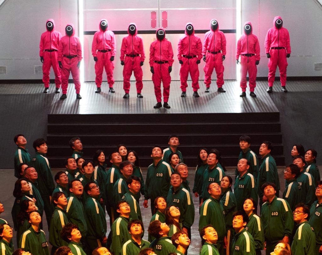 I giocatori di Squid game sono tenuti costantemente sotto controllo da alcune guardie vestite di rosso (Keystone)