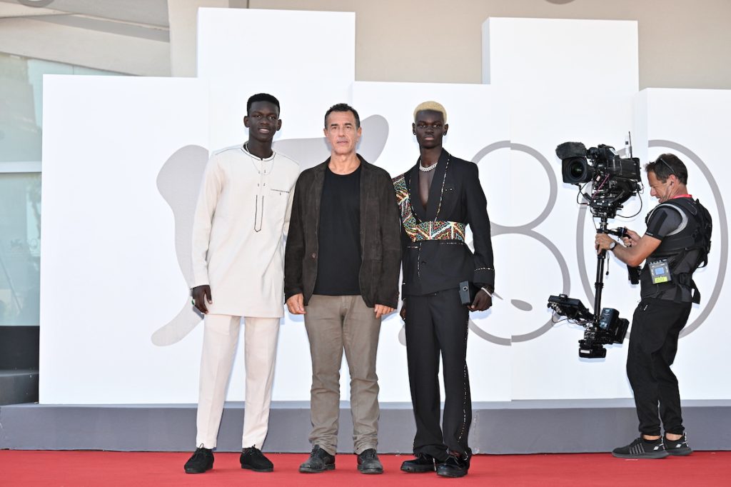 Seydou Sarr, Matteo Garrone e Moustapha Fall sul red carpet a Venezia. (Keystone)