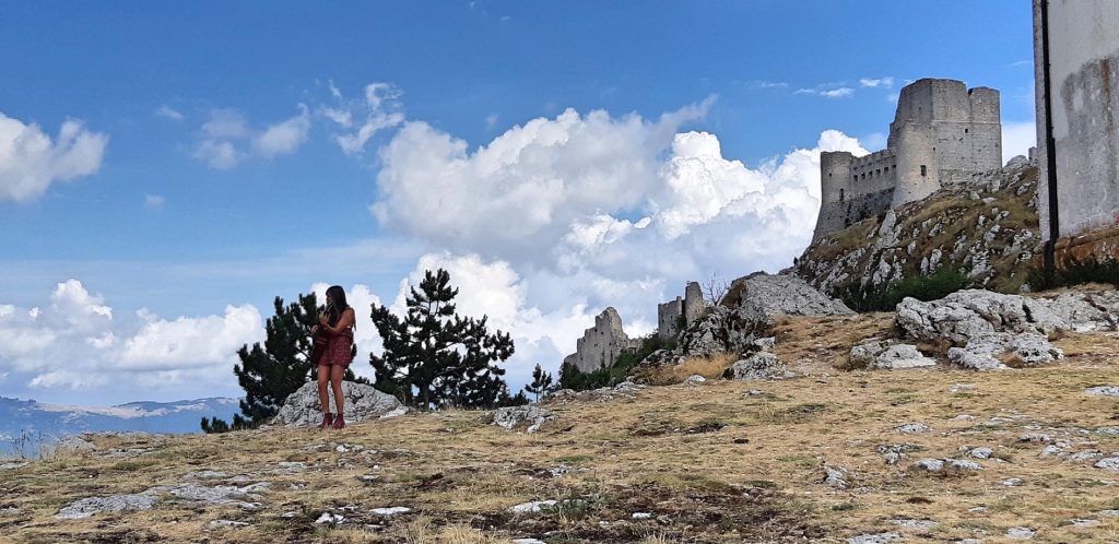 Ragazza con chitarra davanti a Rocca Calascio
