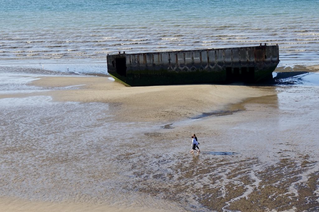La sagoma squadrata e massiccia di un pontone arenato sulla sabbia