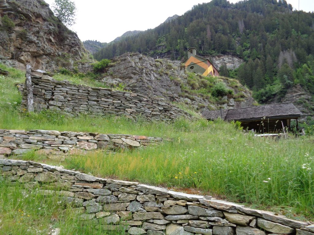 I muri a secco sopra Rossa e una delle tre chiesette riattate (Elia Stampanoni)