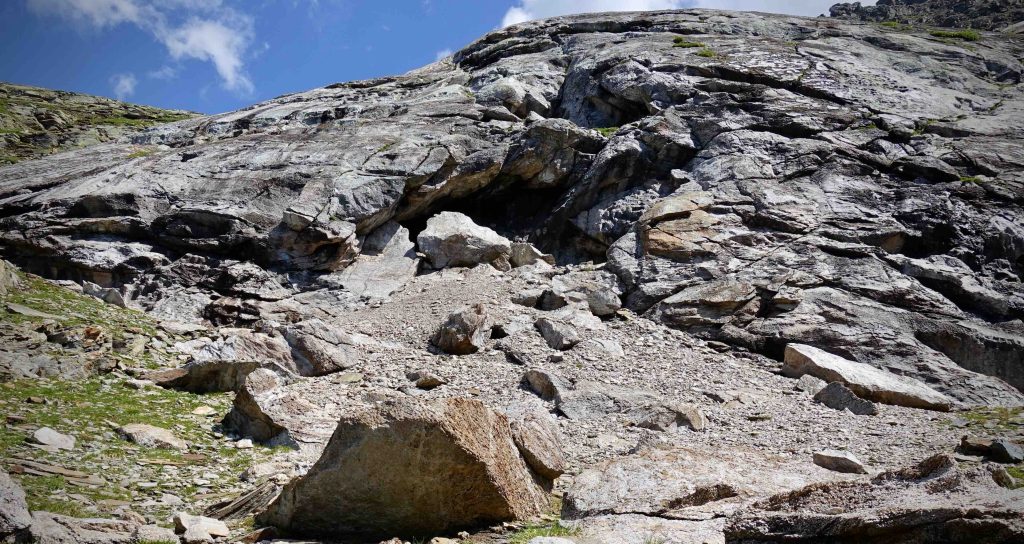 Anfratto alla base della roccia con cumuli residui dell'estrazione