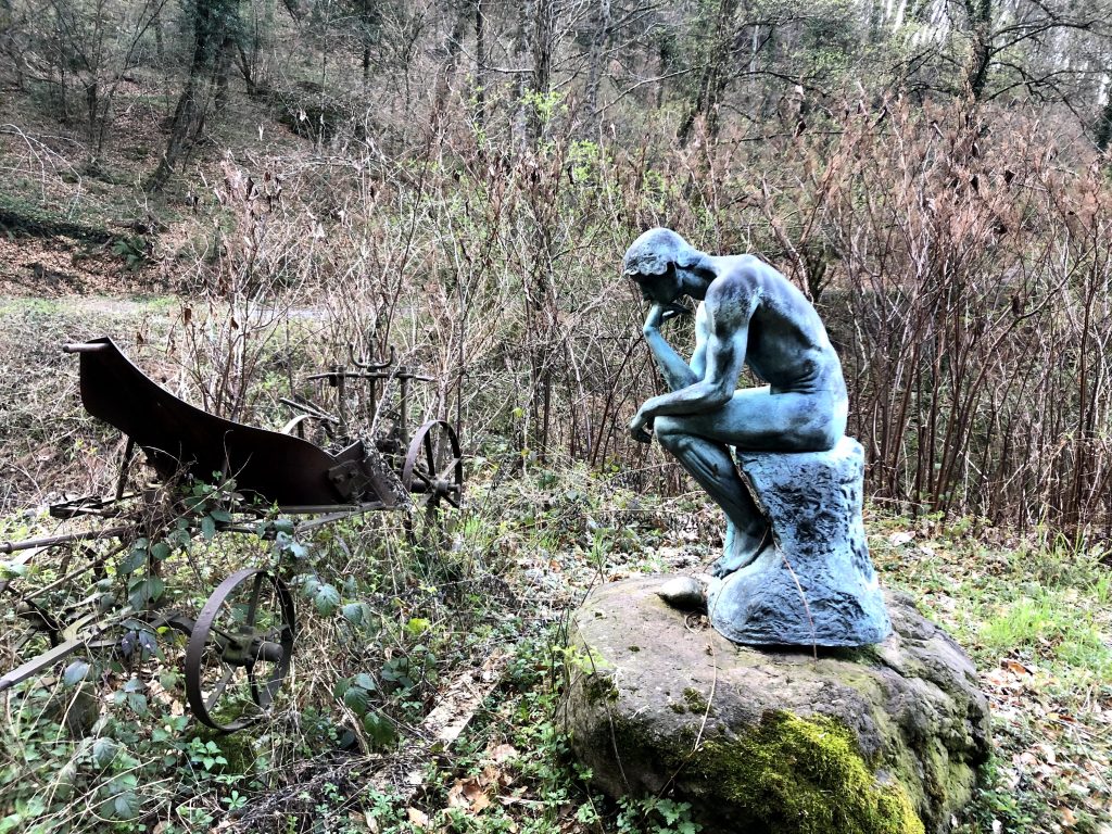Una copia della statua Il pensatore di Rodin, nel contesto della natura selvaggia ticinese.