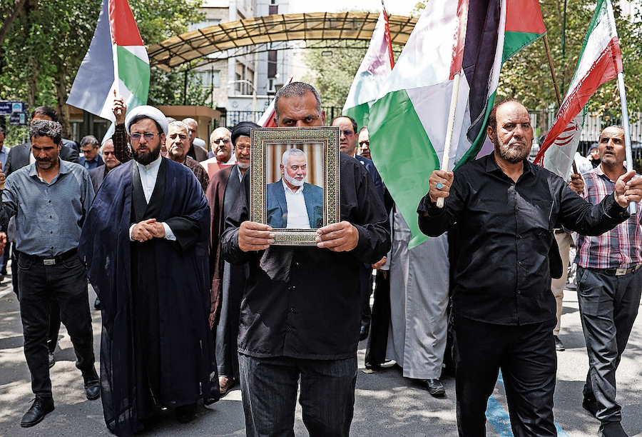 Istantanea da Teheran: iraniani con il ritratto del defunto leader politico di Hamas Haniyeh. (Keystone)