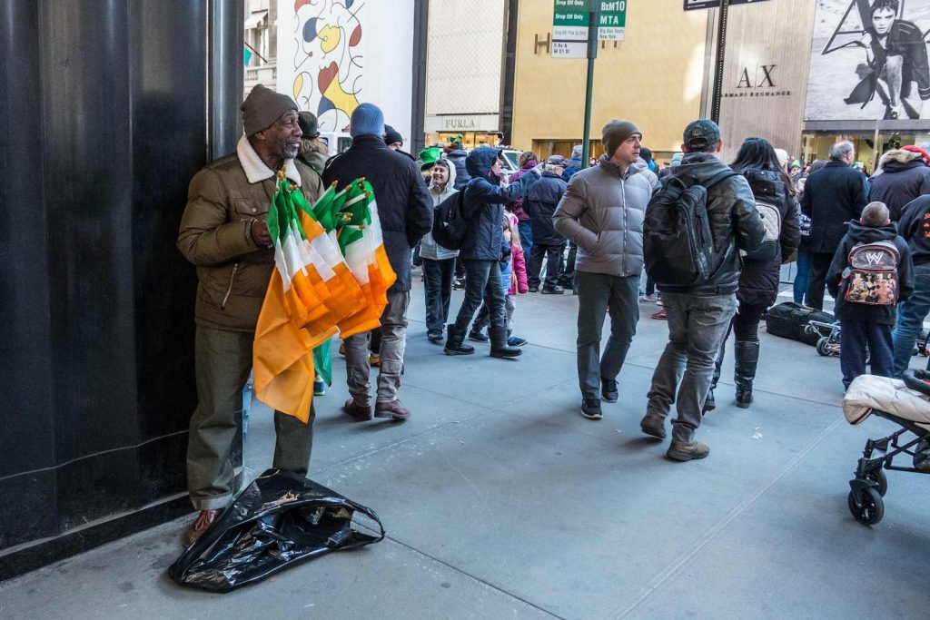 Un ambulante vende bandiere irlandesi prima della parata