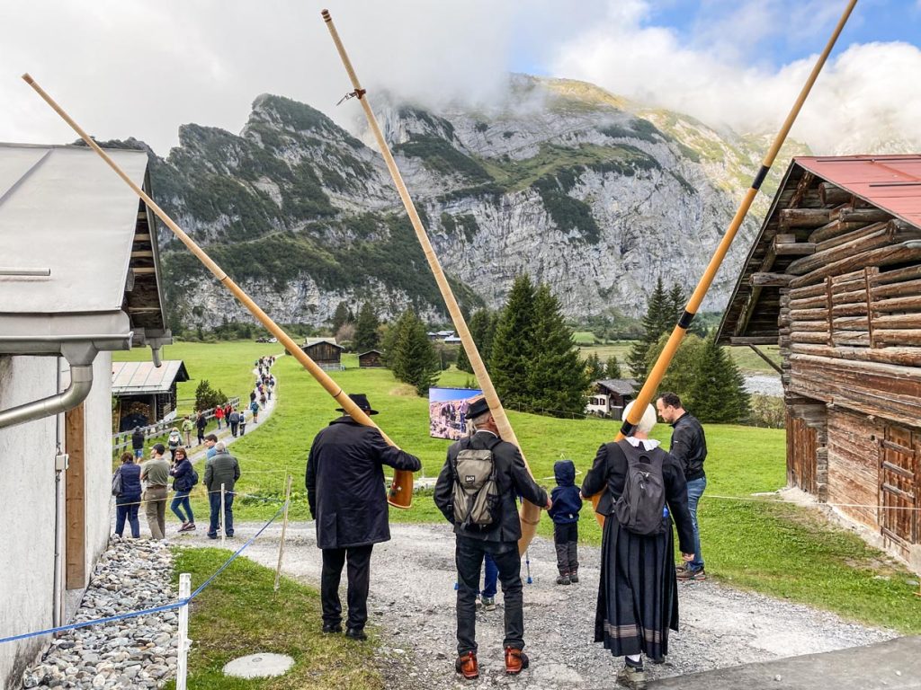 I visitatori iniziano a radunarsi nella piana di Bargis, sullo sfondo il massiccio della catena Flimserstein dove si trova la ripida Scala Mola.