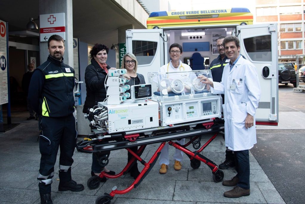 Gisela Vegezzi (a sinistra) e Bernadette Waller (a destra) insieme al personale sanitario al momento della consegna della nuova incubatrice da trasporto per ambulanza ed elicottero