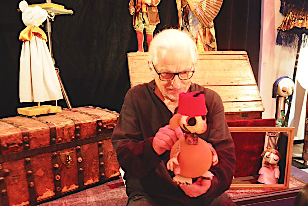 Il marionettista tra le sue creazioni