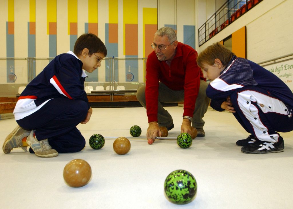 Al Palapenz di Chiasso Arturo Marinoni in una foto d’archivio insegna le regole fondamentali del gioco delle bocce a due giovanissimi (Ti-Press)