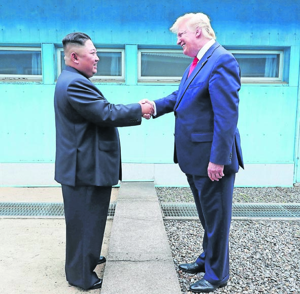 Kim e Trump si stringono la mano nella zona demilitarizzata fra le due Coree (AFP)