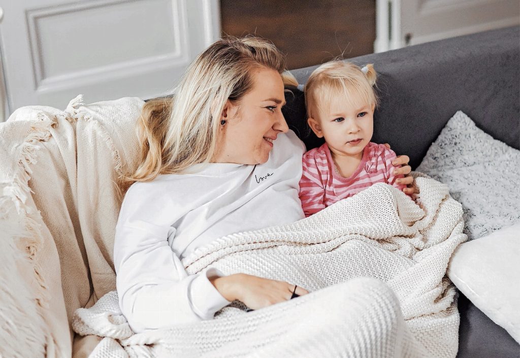 I genitori fautori della teoria del «fare meno» possono trascorrere un intero pomeriggio a guardare un film con i propri figli sul divano senza sentirsi in colpa. (Pexels)