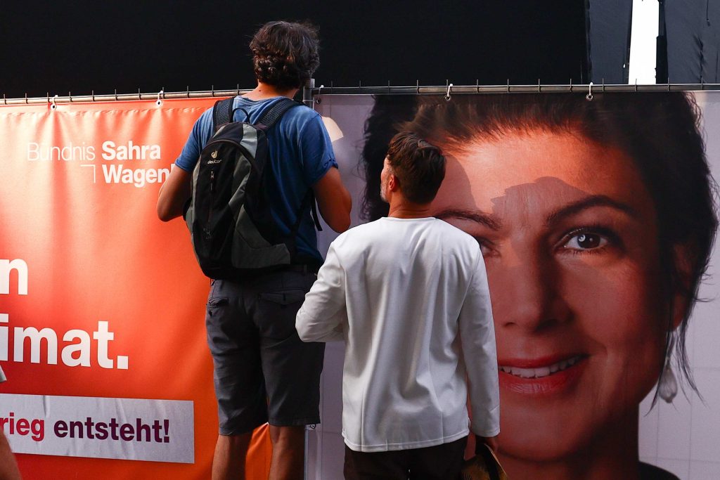 A Dresda due passanti osservano il manifesto elettorale di Sahra Wagenknecht. (Keystone)