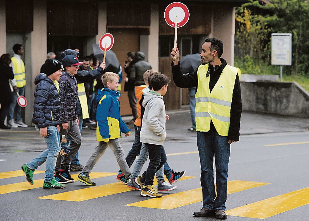 Richiedente l’asilo che si presta come pattugliatore scolastico (Keystone)