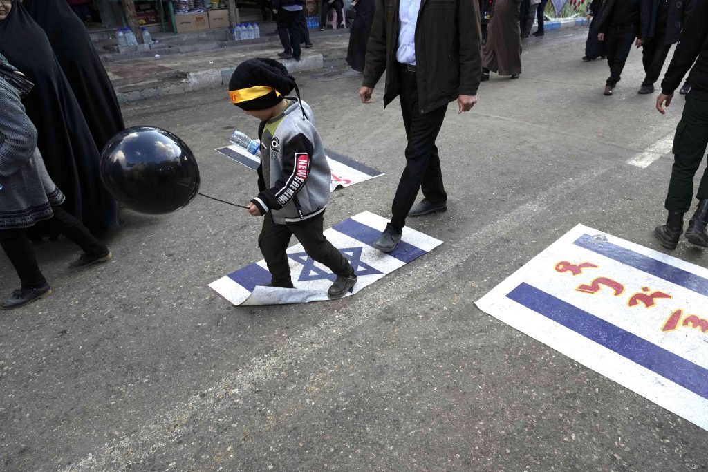 C'è chi cammina sulla bandiera israeliana nella città di Kerman, in Iran, teatro di esplosioni che hanno causato la morte di oltre un centinaio di persone (Keystone)