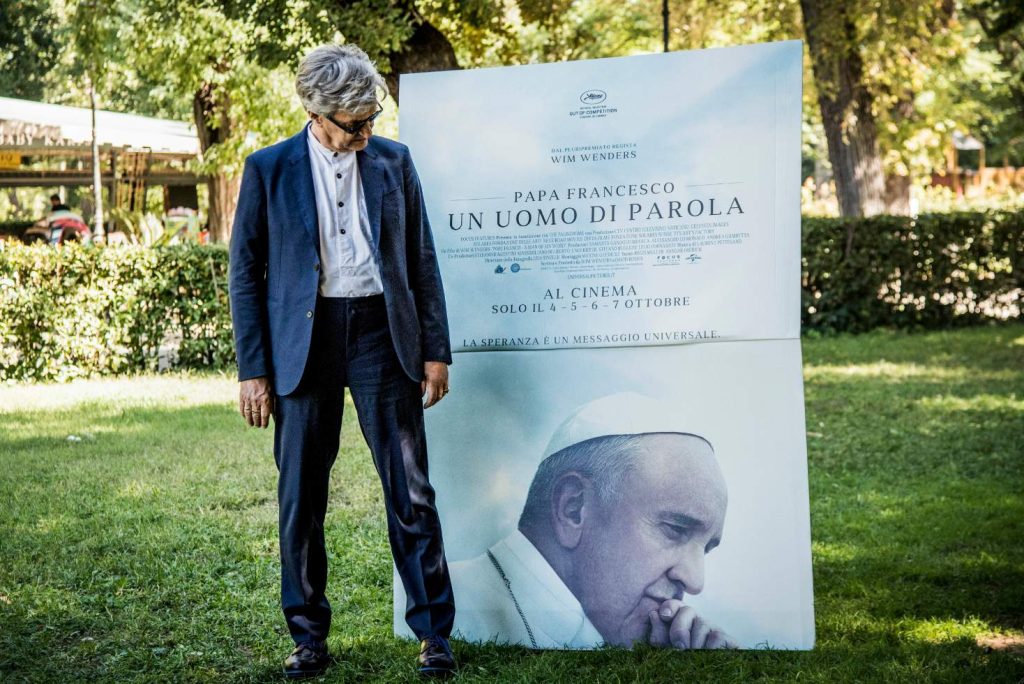 Wim Wenders accanto al poster del suo nuovo film in una foto scattata recentemente a Roma (Keystone)