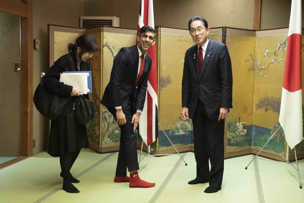 Il primo ministro inglese Rishi Sunak mostra le caviglie a Fumio Kishida (Keystone)