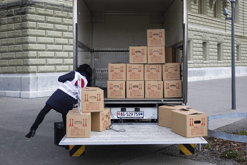Camion carico di scatoloni con le firme di un referendum davanti alla Cancelleria federale a Berna (Keystone)