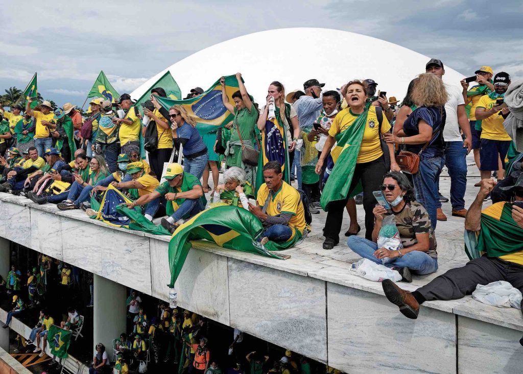 Sostenitori di Bolsonaro sul tetto dell’edificio del Congresso nazionale, a Brasilia, l’8 gennaio scorso (Keystone)