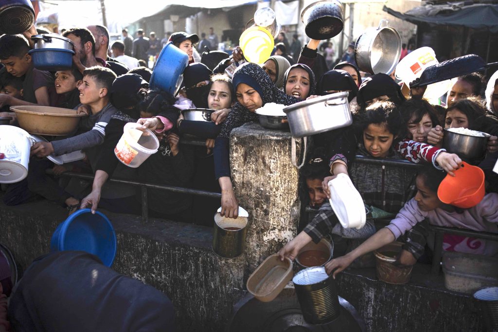 Palestinesi in attesa di un pasto a Rafah, Striscia di Gaza (Keystone)