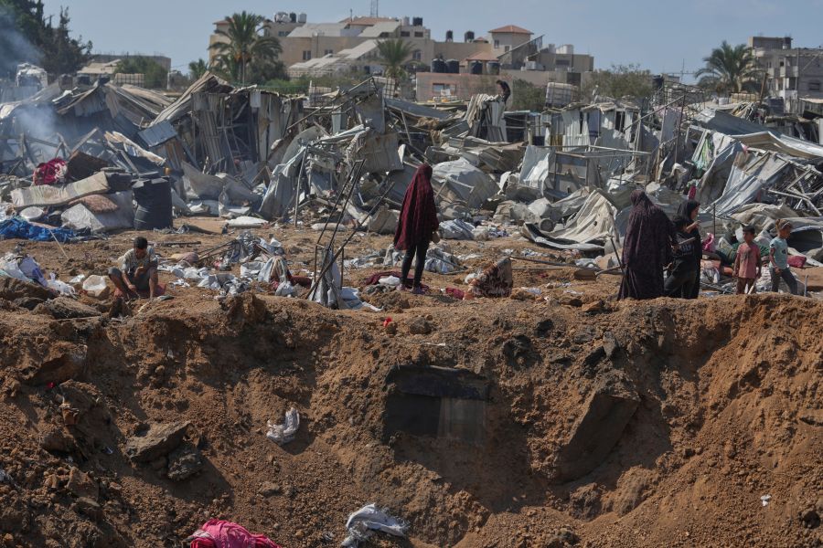 Palestinesi in piedi davanti al cratere creato da attacchi israeliani nel campo di tende per le persone dislocate nei pressi dell’ospedale Al-Aqsa Hospital, a Deir al-Balah.

(Keystone)
